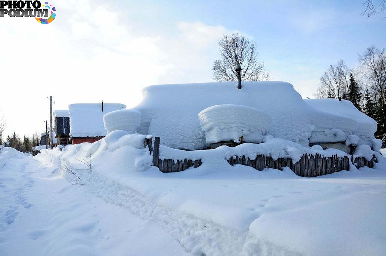 Село занесенное снегом оттаивает по немногу. Много снега. Сугробы в деревне. Дом занесло снегом. Зима много снега.
