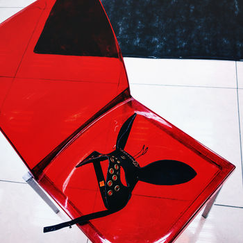 Mask on red plastic chair