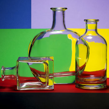 Натюрморт с бутылками на цветном фоне