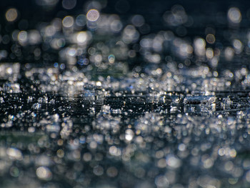 Silvery fragments of ice in the rays of the March sun in the southern seaside Park.