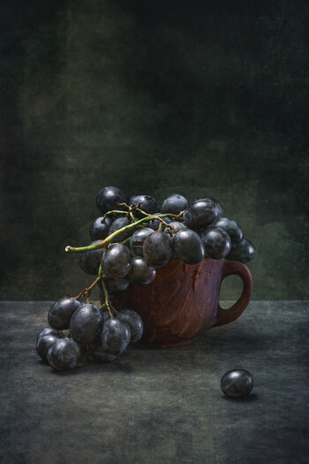 Тёмный виноград в коричневой чашке
