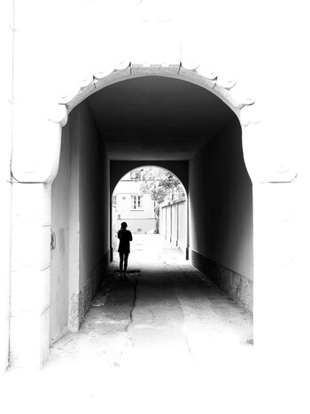 The silhouette of a girl in the arch of the old town.